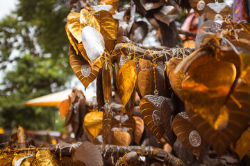 Golden leaves on traditional religious offerings in a buddhist temple in Chiang Rai, Thailand
