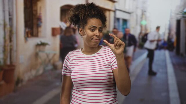 Woman pinching thumb and forefinger to indicate tiny size on a busy city street; teasing measurement amusement.