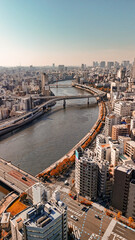 Obraz premium Drone aerial view of Tokyo Japan with skyscrapers, roads, and city landmarks in daylight from Taito City