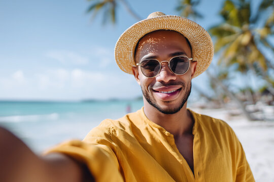 A man wearing a yellow shirt and a straw hat is smiling and taking a selfie