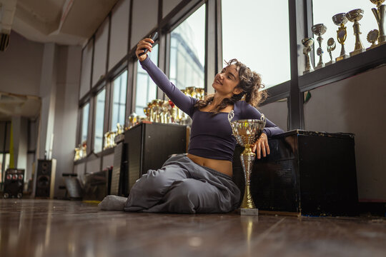 Young woman taking selfie celebrating dance success in studio