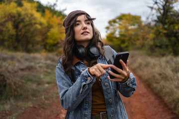 Woman hiking in nature checking smart phone navigation app