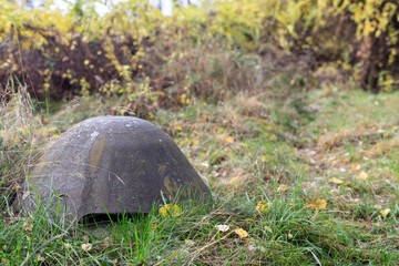 Obraz premium Stalowa czapka schronu bunkra na tle pożółkłych jesiennych traw