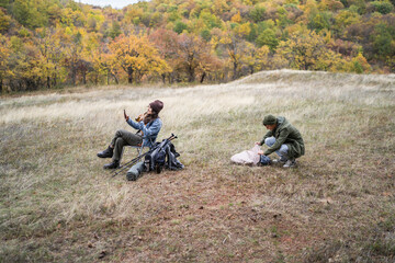 Couple relaxing and setting up camp during autumn hiking trip