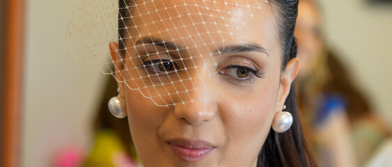 Soft bridal moment with bride placing sparkling earrings while getting ready for her wedding day