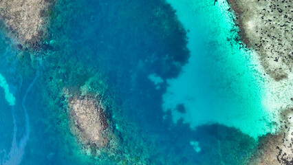 Aerial view of Pulau Karangan in Komodo National Park showing vibrant coral reefs and turquoise waters