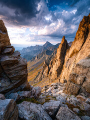 Fototapeta premium Majestic mountain landscape with rugged peaks under dramatic cloud-filled sky