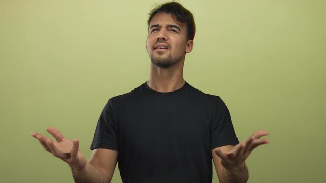 Young hispanic man over isolated yellow background expresses frustration with upward gestures and an emotional expression.