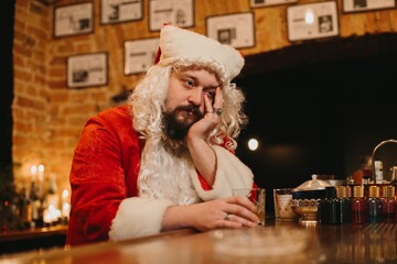 Tired santa claus drinking at bar counter