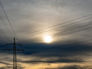 Hochspannungsmasten unter einem bizarren Wolkenhimmel
