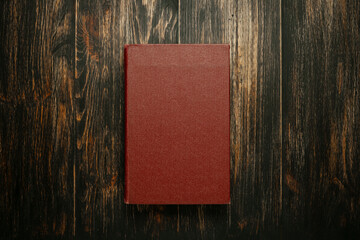 Blank burgundy book cover centered on a rich, dark, rustic wooden back