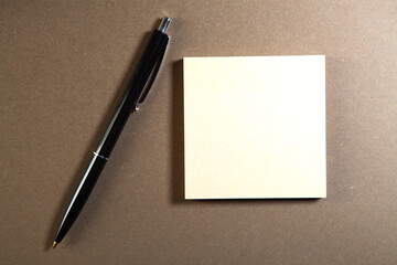 note paper and pen on brown background, copy space for add text