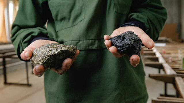 Geologist holding green and dark stones in both hands, core samples