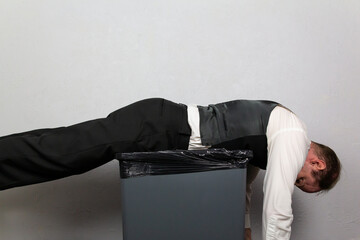Businessman Tossed Onto Trash Can. Concept of Being Sacked or Fired.