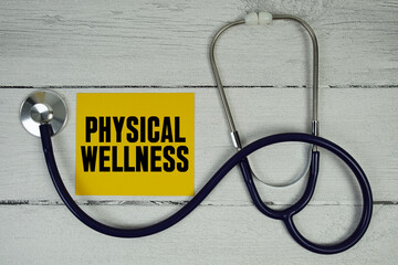 Physical Wellness text with Magnifying glass and Medical Stethoscope on wooden background