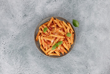 Italian pasta penne arrabiata with tomato sauce and chili pepper on blue background. Top view. Copy space