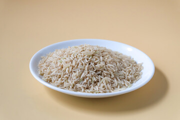 Raw Brown rice, uncooked and hulled in plate.