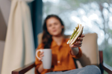 Woman enjoying a healthy snack with avocado toast and a cup of tea in a cozy setting, portraying a...