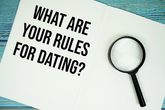 What Are Your Rules For Dating? text written on notepad with magnifying glass flat lay on wooden background