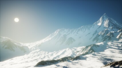 Snow covered peaks rise dramatically against a vibrant blue sky while the sun casts a warm glow over the serene winter landscape, creating a breathtaking natural spectacle.