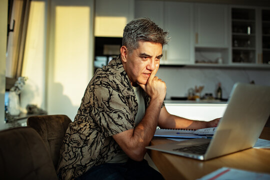 Middle-aged man working on laptop at home