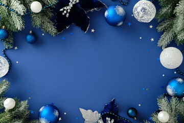 Festive border of pine branches and ornaments in blue and silver tones on a blue background. Christmas, New Year, winter holidays greeting card template, banner design.