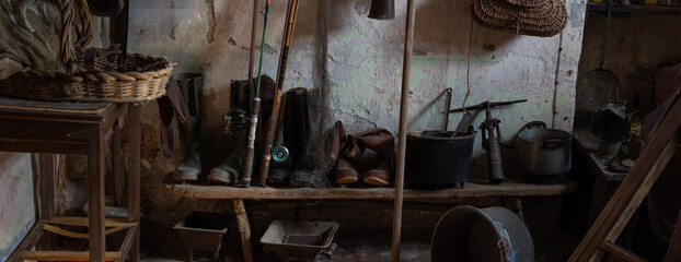 Vintage Fishing Tools and Equipment on Rustic Wooden Shelves in Old Workshop Storage Room