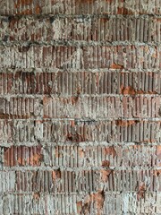 Weathered red brick wall with rust stains, cracks, and peeling mortar, evoking a rustic, aged industrial texture for vintage urban backdrops