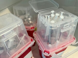 Medical sharps containers filled with used syringes for safe disposal