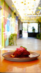 Platillo tradicional mexicano bañado en salsa roja, decorado con cebolla morada encurtida y rodajas de chile verde.