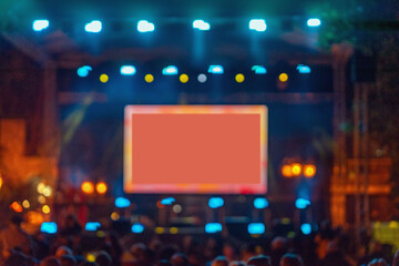 Blurred concert stage with glowing screen and bright lights, creating dynamic atmosphere with copy space for text or branding. Concept of live show, digital display, event
