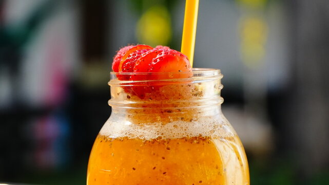 Jarro grande con bebida de pi&ntilde;a, adornado con frutos rojos encima con un popote