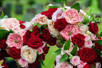 Closeup funeral flower wreath with red and pink roses.