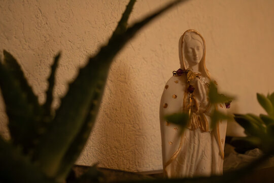 figura de la virgen de guadalupe, en color blanco  con detalles dorados y flores al rededor 