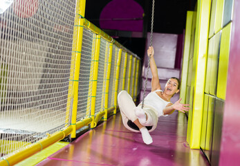 Happy girl goes down a zip line at high speed in an amusement park. Storm of emotions and delight