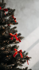A decorated Christmas tree with red bows and lights. The tree has a dark green color and is adorned with colorful accents. The background is softly lit.