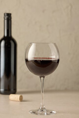 closeup of red wine glass and bottle
