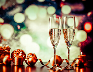 two champagne glasses against holiday lights and fireworks - new year celebration