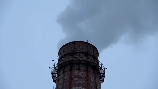 Cooling Tower Emitting Steam into Sky, Industrial Power Plant Infrastructure, Hyperboloid Structure with Misty Vapor Against Blue Background