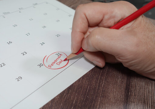 Close up of man writing retirement day on calendar - Powered by Adobe