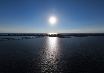 An aerial view shows Rodanthe Bridge commonly called the Jug Handle Bridge crossing a wide ocean, carries North Carolina Highway 12 from Rodanthe to the southern point of Pea Island