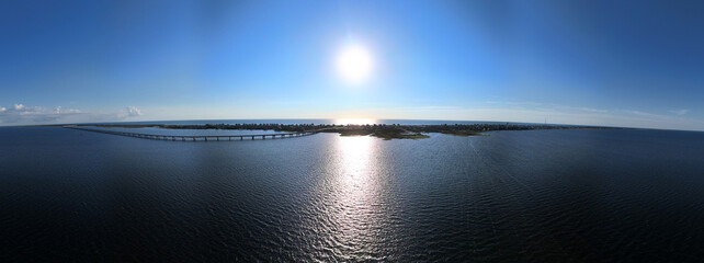 An aerial view shows Rodanthe Bridge commonly called the Jug Handle Bridge crossing a wide ocean, carries North Carolina Highway 12 from Rodanthe to the southern point of Pea Island
