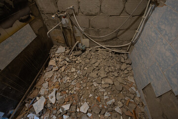 Demolishing old tiles and plaster from bathroom walls, creating a messy scene with construction...