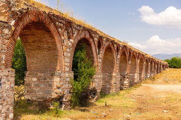 Arched spans of aqueduct spread over large distances in sultry steppe of northern Macedonia....