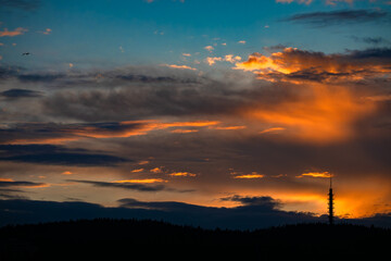 Obraz premium Nordic summer sunset sky with clouds and silhouette tower