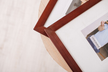 Close-up of two photo frames with pictures on wooden table.