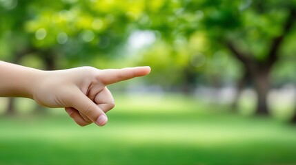 Child’s hand pointing forward in green nature background symbolizing curiosity, learning and discovery in education and innocence context, Generative AI