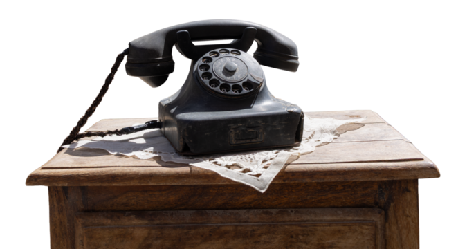 Vintage black rotary telephone on wooden table with blue background