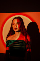 Beautiful woman in elegant dress with artistic lighting on her face in a creative studio setting