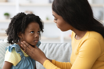 Obraz premium A mother is gently talking to her daughter in a warm and inviting living room. They share a heartfelt moment, showing a bond of love and understanding in the afternoon light.